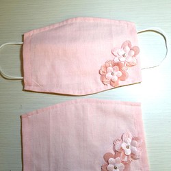 薄ピンク色のマスクカバー 花飾り付き 1枚目の画像
