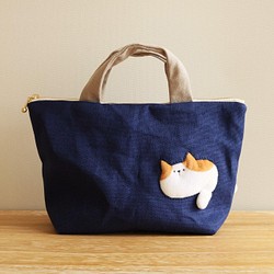 バッグを通り抜けようとする猫の小さめバッグ (茶×白猫 ネイビー系 ファスナー25cm ランチバッグ) 1枚目の画像