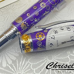 紫のカーボンファイバーの上に腕時計のゼンマイ・ネジ・文字盤などを乗せたペン 1枚目の画像