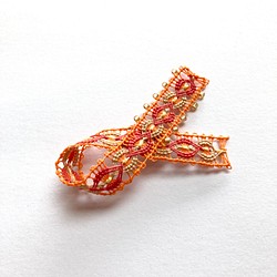 糸のリボンモチーフのブローチ　オレンジ 1枚目の画像