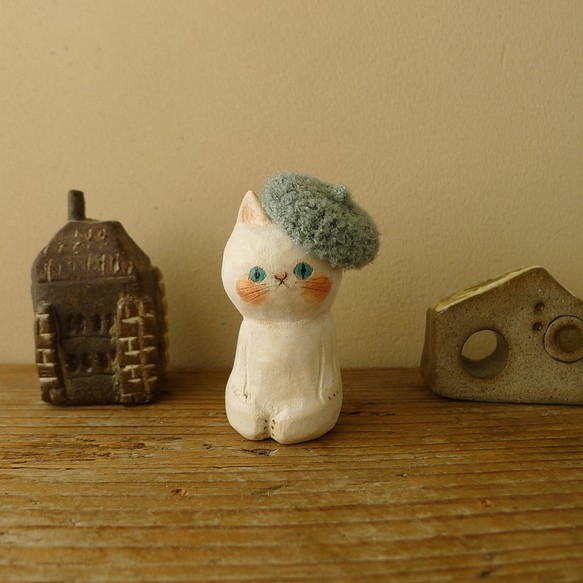 冬の木彫り・くすんだ水色のベレー帽を被った白猫 1枚目の画像