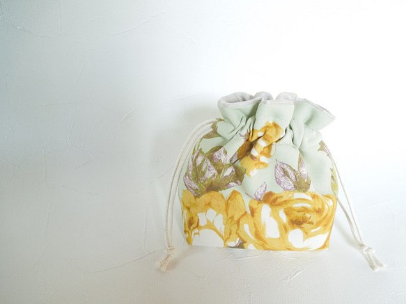 若草色にマスタードの大きなお花柄が華やかなコロンとした巾着ポーチ：受注製作です 1枚目の画像