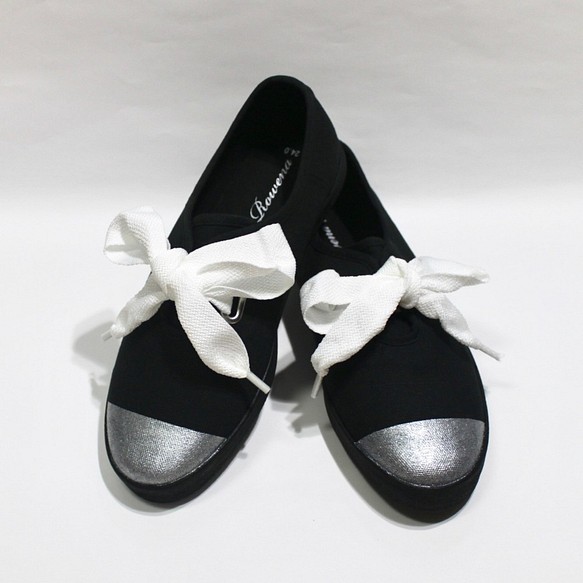黑色運動鞋，配以白絲帶和銀色小提示 第1張的照片